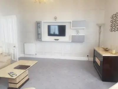 a living room with a flat screen tv on the wall at Promenade Apartments in Southport