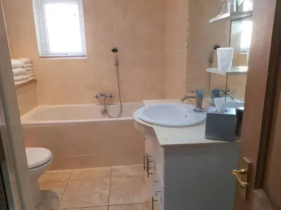 a bathroom with a sink and a tub and a toilet at Promenade Apartments in Southport