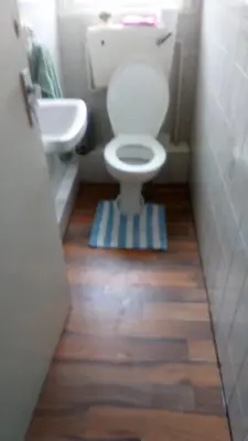a bathroom with a toilet and a sink on a wooden floor at The Driftwood Hotel in Blackpool