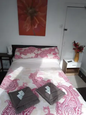 a bedroom with a bed with a red and white comforter at The Driftwood Hotel in Blackpool