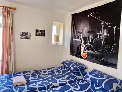 a bedroom with a bed with a guitar on the wall at The Blue Moon in Blackpool