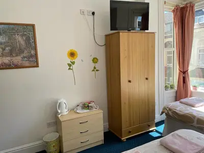 a bedroom with a dresser with a television on top at The Blue Moon in Blackpool