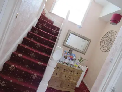 a staircase in a home with a red carpeted stair at The Heidi Bed & Breakfast in Southport