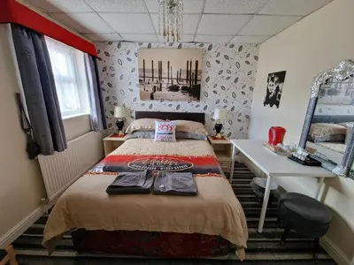 a bedroom with a bed and a desk and a mirror at BUKHARI Hotel in Blackpool