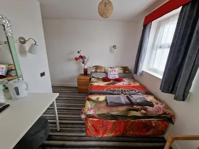 a small room with a bed and a window at BUKHARI Hotel in Blackpool