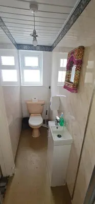 a bathroom with a toilet and a sink and a mirror at BUKHARI Hotel in Blackpool