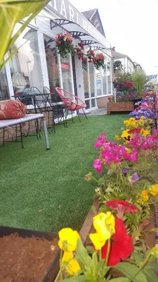 a patio with flowers in front of a store at BUKHARI Hotel in Blackpool