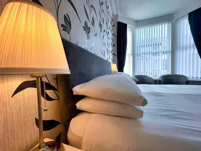 a bedroom with a bed with a lamp and pillows at Bella Vista Lodge in Blackpool