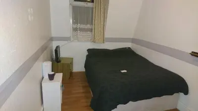 a small bedroom with a bed and a window at MyRoomz Orchid Hotel in Blackpool