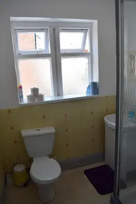 a bathroom with a toilet and a window at MyRoomz Orchid Hotel in Blackpool