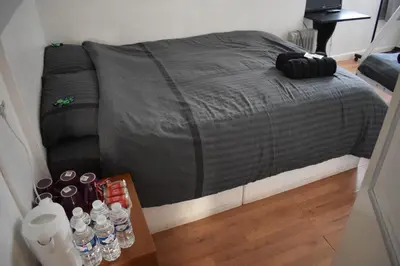 a bed in a room with a table with bottles of water at MyRoomz Orchid Hotel in Blackpool