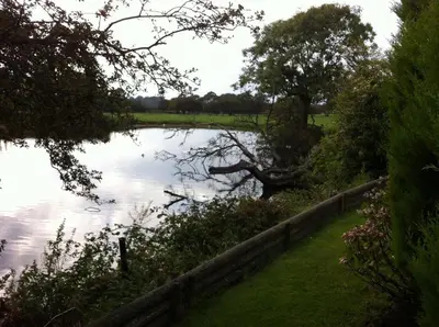 a body of water with a fence next to it at Merok Lodge in Great Eccleston