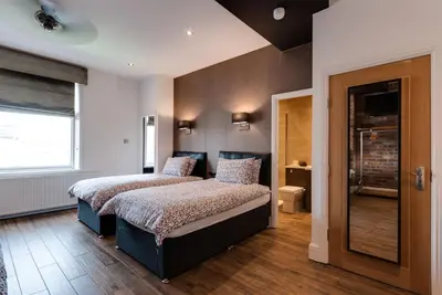 a bedroom with two beds and a window at Tom Thumb Apartments in Liverpool