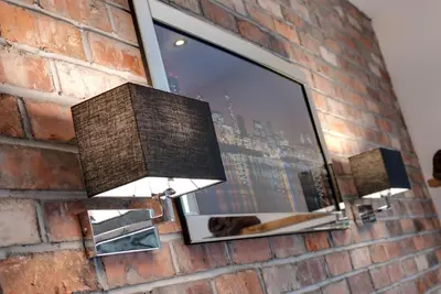 a light on a brick wall with a window at Tom Thumb Apartments in Liverpool