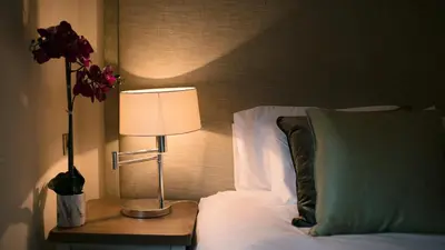 a bed with a table with a lamp and a pillow at No.10 Preston in Preston