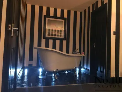 a bath tub in a bathroom with black and white stripes at No.10 Preston in Preston