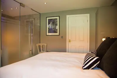 a bedroom with a white bed with a glass door at No.10 Preston in Preston