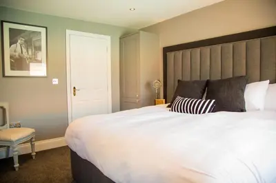 a bedroom with a large white bed and a chair at No.10 Preston in Preston
