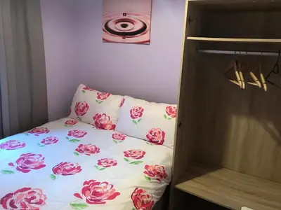 a small bedroom with a bed with flowers on it at Aparthotel Coniston in Blackpool