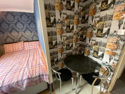 a bedroom with a bed and a table and chairs at Aparthotel Coniston in Blackpool