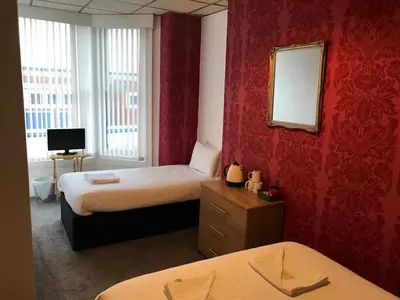 a hotel room with two beds and a mirror at The Orbiston in Blackpool