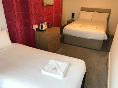 a hotel room with two beds and a mirror at The Orbiston in Blackpool