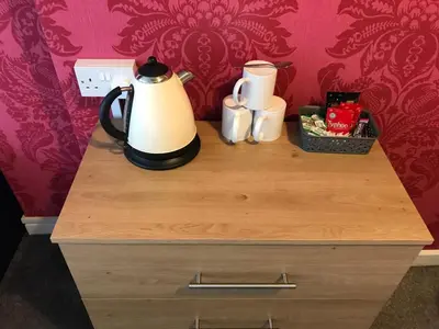 a nightstand with a tea kettle and cups on it at The Orbiston in Blackpool