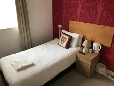a bedroom with a bed and a night stand with a pillow at The Orbiston in Blackpool