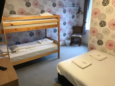 a room with two bunk beds and a chair at The Orbiston in Blackpool