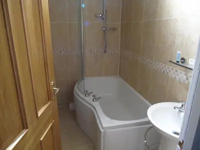 a bathroom with a bath tub and a sink at Jeffersons Abbey Road Serviced Apartments in Barrow in Furness