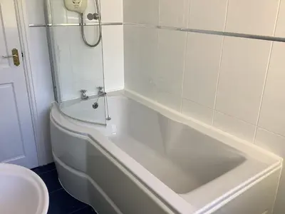 a bathroom with a shower and a tub and a toilet at Jeffersons Abbey Road Serviced Apartments in Barrow in Furness