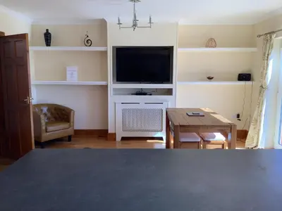a living room with a television and a table at Jeffersons Abbey Road Serviced Apartments in Barrow in Furness