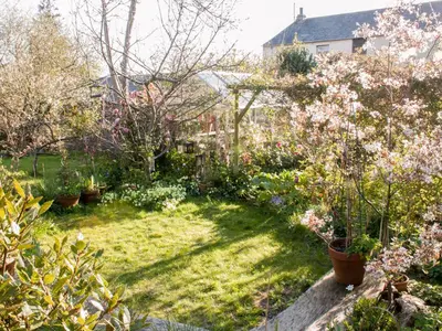 a garden with trees and flowers in a yard at Woodburn Cottage in Soutergate