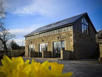 a large brick building with a black roof at 3 Millstones Inn in West Bradford