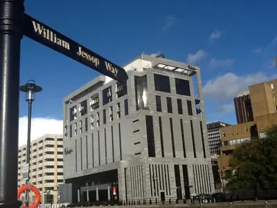 a tall building with a street sign on a pole at Excelsior Apartments - Liverpool Central - Free Parking - AirCon in Liverpool