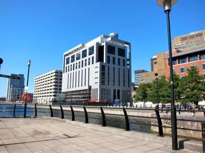 a tall white building next to a body of water at Excelsior Apartments - Liverpool Central - Free Parking - AirCon in Liverpool