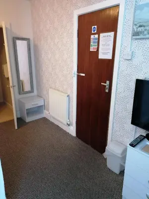 a bathroom with a toilet and a wooden door at The Kirkview in Blackpool