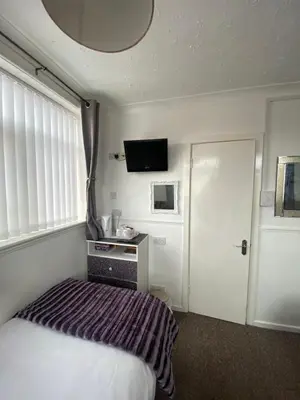 a hotel room with a bed and a television at Mayfair Hotel in Blackpool