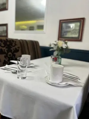 a table with a white table cloth and a glass of water at Mayfair Hotel in Blackpool