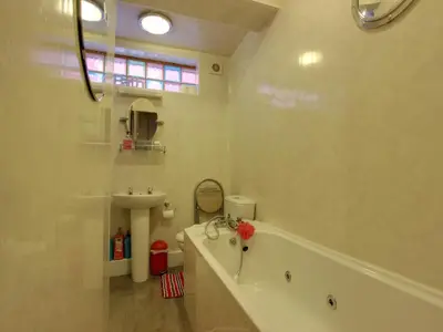 a white bathroom with a tub and a sink at Mayfair Hotel in Blackpool