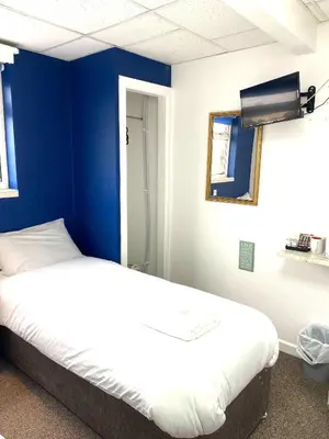 a room with two beds and a blue wall at The Regency Hotel in Blackpool