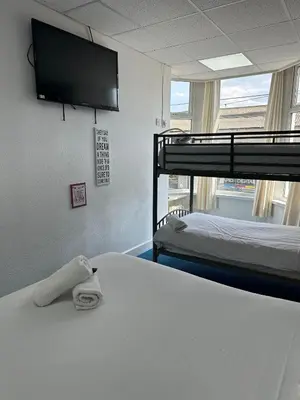 a room with two bunk beds and a flat screen tv at The Regency Hotel in Blackpool
