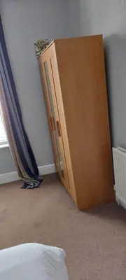 a wooden cabinet in the corner of a bedroom at Mersey View, Two Bedroom Apartment, Liverpool in Waterloo
