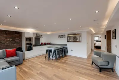 a kitchen and living room with a couch and a table at The Picture House Apartments in Liverpool