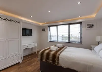 a bedroom with a bed and a desk and a window at The Picture House Apartments in Liverpool