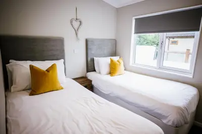 two beds with yellow pillows in a room with a window at Ream Hills Holiday Park in Blackpool
