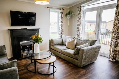 a living room with a couch and a table at Ream Hills Holiday Park in Blackpool