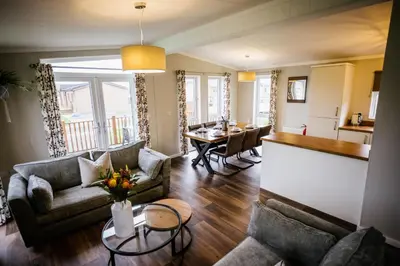 a living room with two couches and a table at Ream Hills Holiday Park in Blackpool