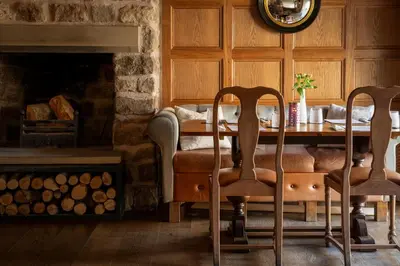 a dining room with a table and chairs and a fireplace at The Royal Heysham in Heysham