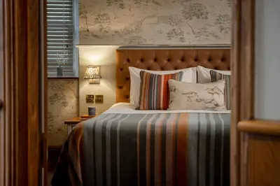 a bedroom with a bed with a striped bedspread at The Royal Heysham in Heysham